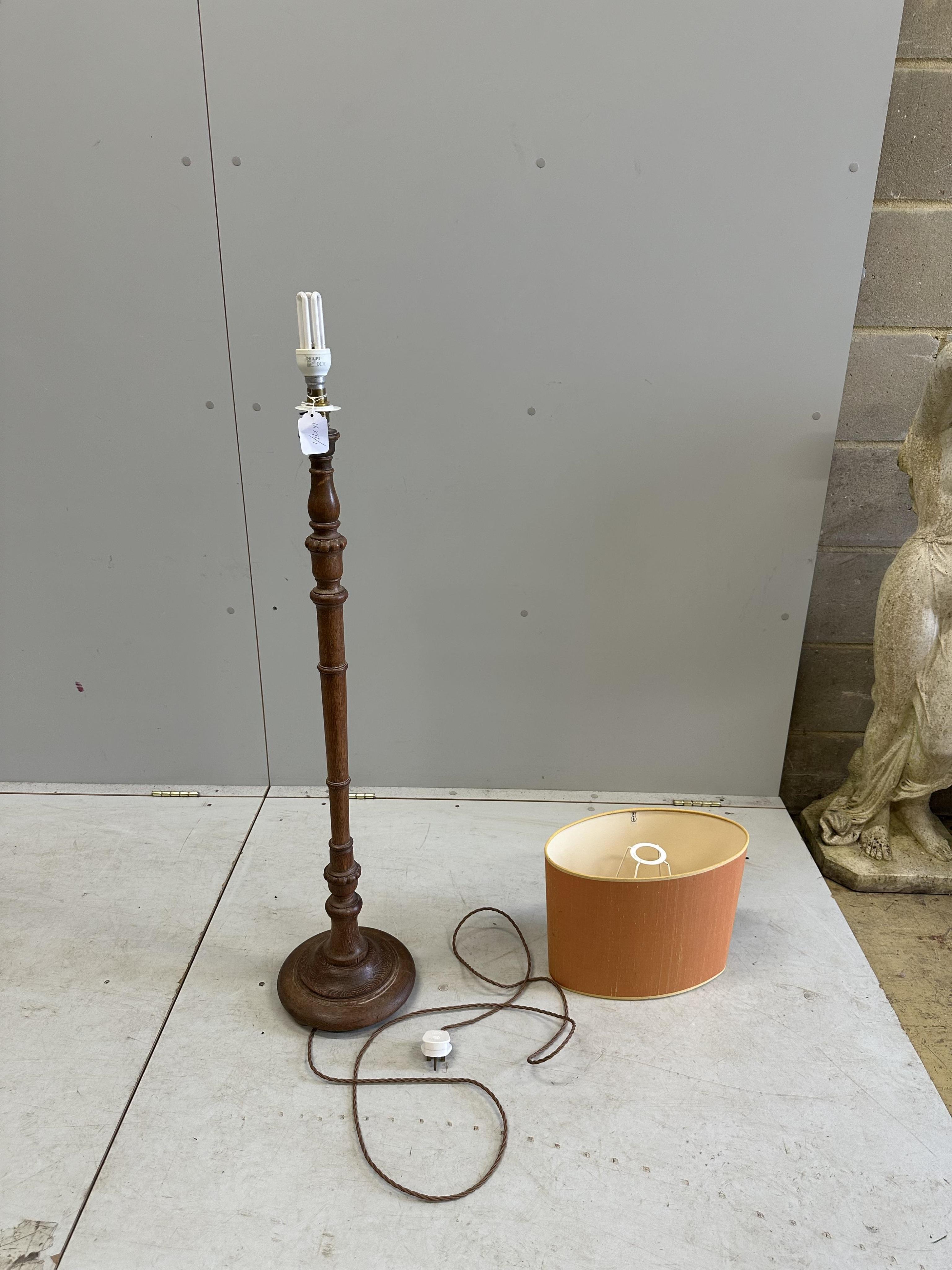 A 1930's turned oak standard lamp, height 97cm plus shade. Condition - good